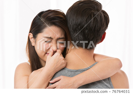 A woman pinching her nose to a man's body odor 76764031