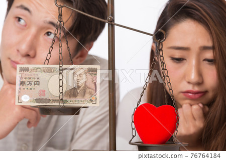 Couple comparing love and money Couple comparing love and money 76764184