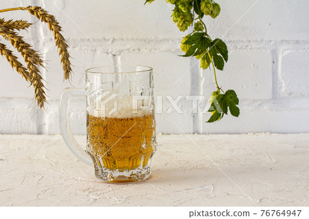 Glass of beer and potato chips on white background. Glass of beer and potato chips on white background. 76764947