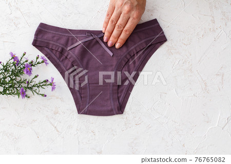 Woman's hand with beautiful panties on white background. 76765082