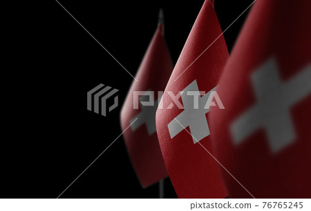 Small national flags of the Switzerland on a black background 76765245