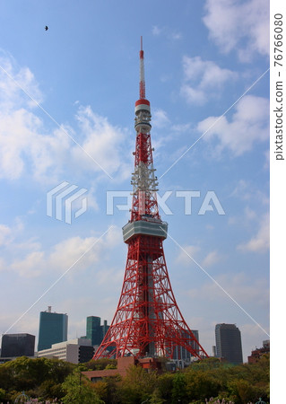 Iconic Tokyo Tower as seen from Shiba Koen (Shiba Park) against a cloudy blue sky Iconic Tokyo Tower as seen from Shiba Koen (Shiba Park) against a cloudy blue sky 76766080