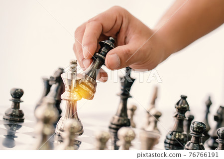 hand of businessman moving chess board game in competition success play 76766191