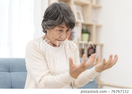 Senior woman with stiff hands Senior woman with stiff hands 76767152