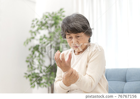 Senior woman with stiff hands Senior woman with stiff hands 76767156