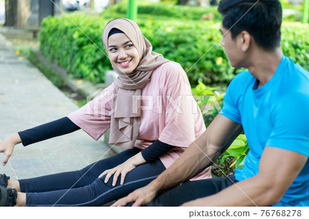 Muslim couples sit back and relax during their exercise Muslim couples sit back and relax during their exercise 76768278
