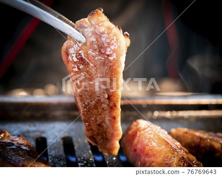 用鉗子夾起的多汁高級烤肉[豬肉托羅] 76769643