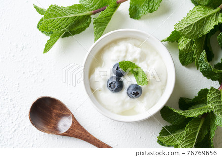 Yogurt topped with blueberries 76769656
