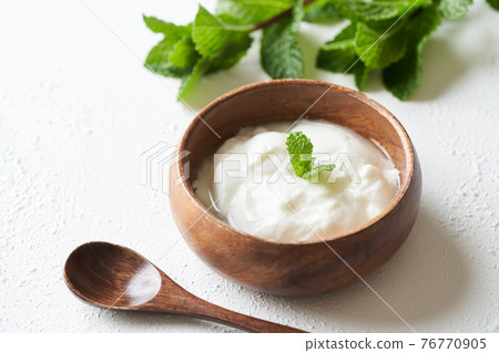 Yogurt served on a wooden bowl 76770905