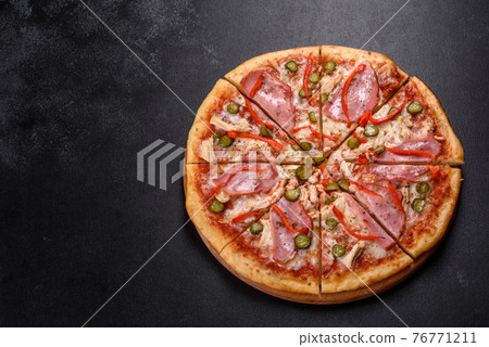 Delicious fresh crispy pizza from the oven with ham and Bulgarian pepper Delicious fresh crispy pizza from the oven with ham and Bulgarian pepper 76771211
