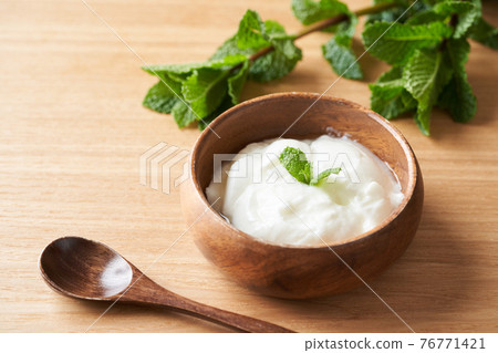 Yogurt served on a wooden bowl Yogurt served on a wooden bowl 76771421