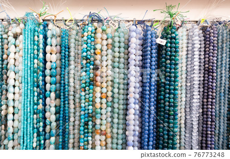 Strands of semiprecious stones on display in bijouterie store 76773248