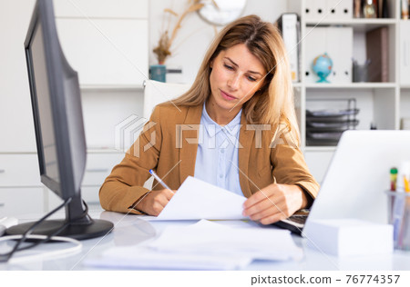 happy female manager working in white room happy female manager working in white room 76774357