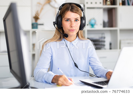 happy adult female operator working in white office 76774633