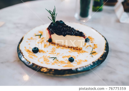 A piece of blueberry cheesecake on the table. 76775359