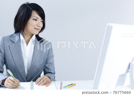 在辦公桌前工作的女商人 76775660