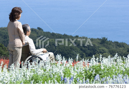 A couple taking a walk in a wheelchair 76776123
