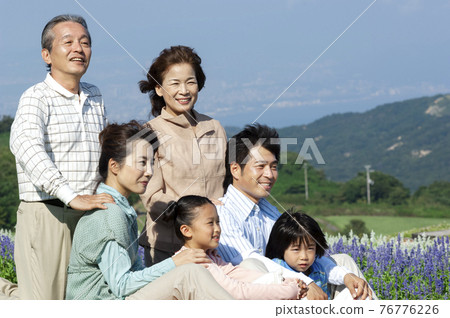 Three generation family sitting in the park 76776226