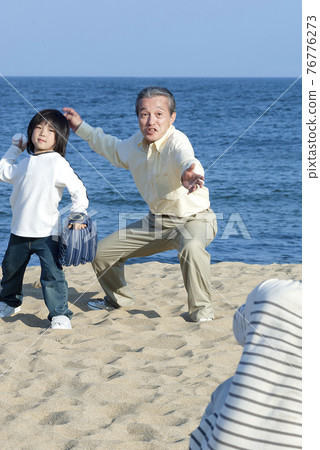 Three generation family playing baseball 76776273