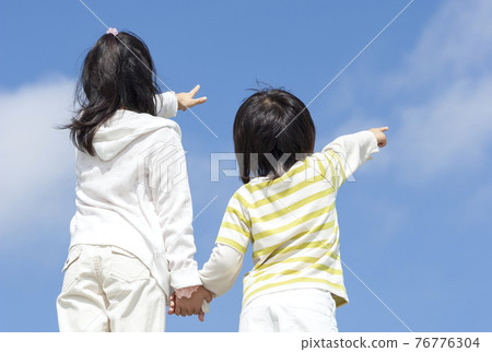 Girls and boys pointing to the sky 76776304