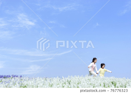 Girls and boys running in the flower field Girls and boys running in the flower field 76776323