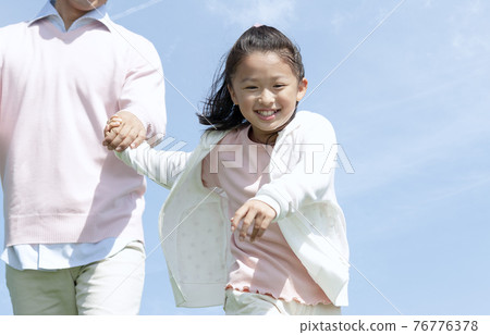 Parent and child running hand in hand Parent and child running hand in hand 76776378