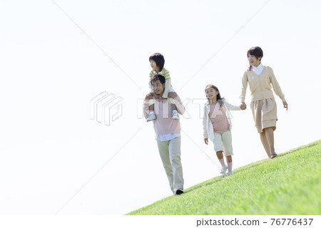 Family walking on the grass 76776437