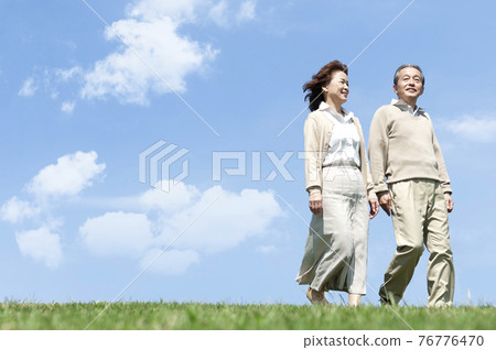 Senior woman walking on the lawn 76776470