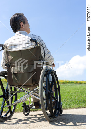 Senior man walking in a wheelchair Senior man walking in a wheelchair 76776524
