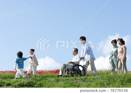 坐在輪椅上的老人和一個微笑的家庭 76776536