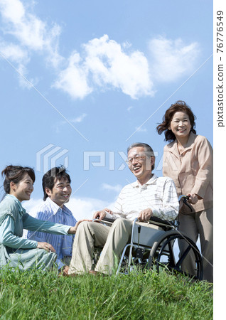 坐在輪椅上的老人和一個微笑的家庭 76776549