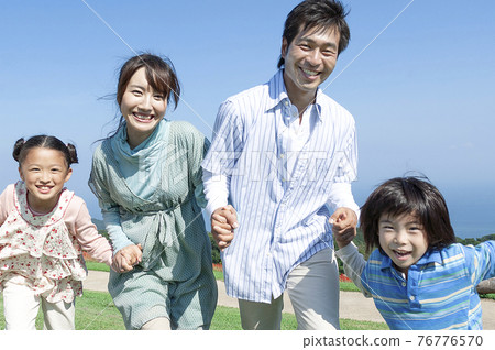 A smiling family holding hands A smiling family holding hands 76776570