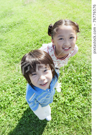 站在草坪上的女孩和男孩 76776576