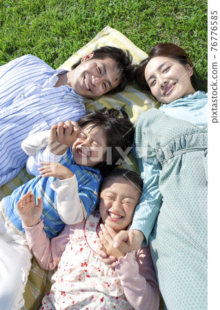 A family lying on the lawn A family lying on the lawn 76776585