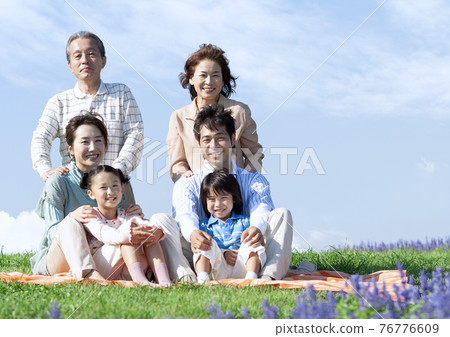 Three generation family sitting on the lawn Three generation family sitting on the lawn 76776609
