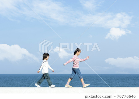 走在防波堤上的女孩和男孩 76776646