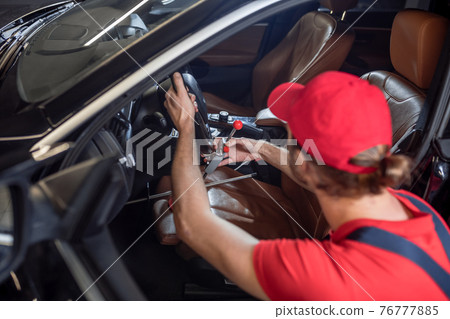 View from back of man repairing car breakdown 76777885