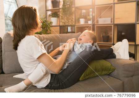 Family time. Mother and daughter having time together at home, look happy and sincere Family time. Mother and daughter having time together at home, look happy and sincere 76779096