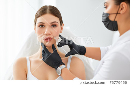 Woman getting beauty injection in salon 76779466