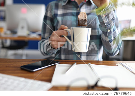 Woman putting tea bag into cup at table closeup 76779645