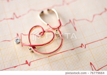 Little toy stethoscope lying on electrocardiogram closeup Little toy stethoscope lying on electrocardiogram closeup 76779664