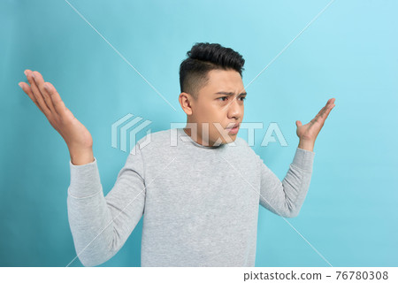 Side view of a angry man shouting and gesturing with hands isolated over blue background Side view of a angry man shouting and gesturing with hands isolated over blue background 76780308