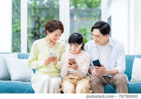 Middle family looking at a smartphone in the living room 76780600