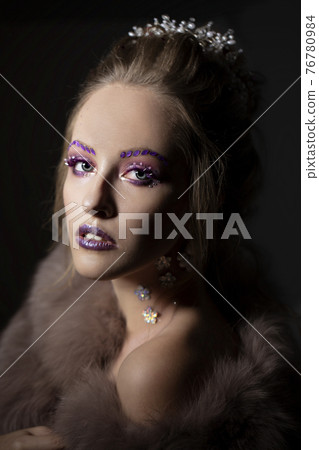 Luxurious girl with a beautiful make-up in a fur coat. Beauty in furs. Model on a dark background. Young beautiful woman. Luxurious girl with a beautiful make-up in a fur coat. Beauty in furs. Model on a dark background. Young beautiful woman. 76780984