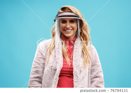 Young stylish woman wearing face shield against blue background Young stylish woman wearing face shield against blue background 76784131