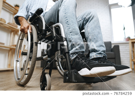 Unrecognizable disabled man sitting in a wheelchair Unrecognizable disabled man sitting in a wheelchair 76784259