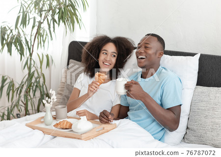 Couple in love having breakfast in bed during honeymoon in covid-19 and enjoying rest 76787072