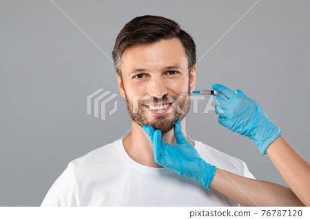 Unrecognizable cosmetician injecting face filler for middle-aged man Unrecognizable cosmetician injecting face filler for middle-aged man 76787120