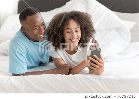 Honeymoon, self-isolation and online call to family, young couple in bed Honeymoon, self-isolation and online call to family, young couple in bed 76787216