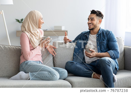 Young muslim couple drinking tea and talking at home Young muslim couple drinking tea and talking at home 76787238